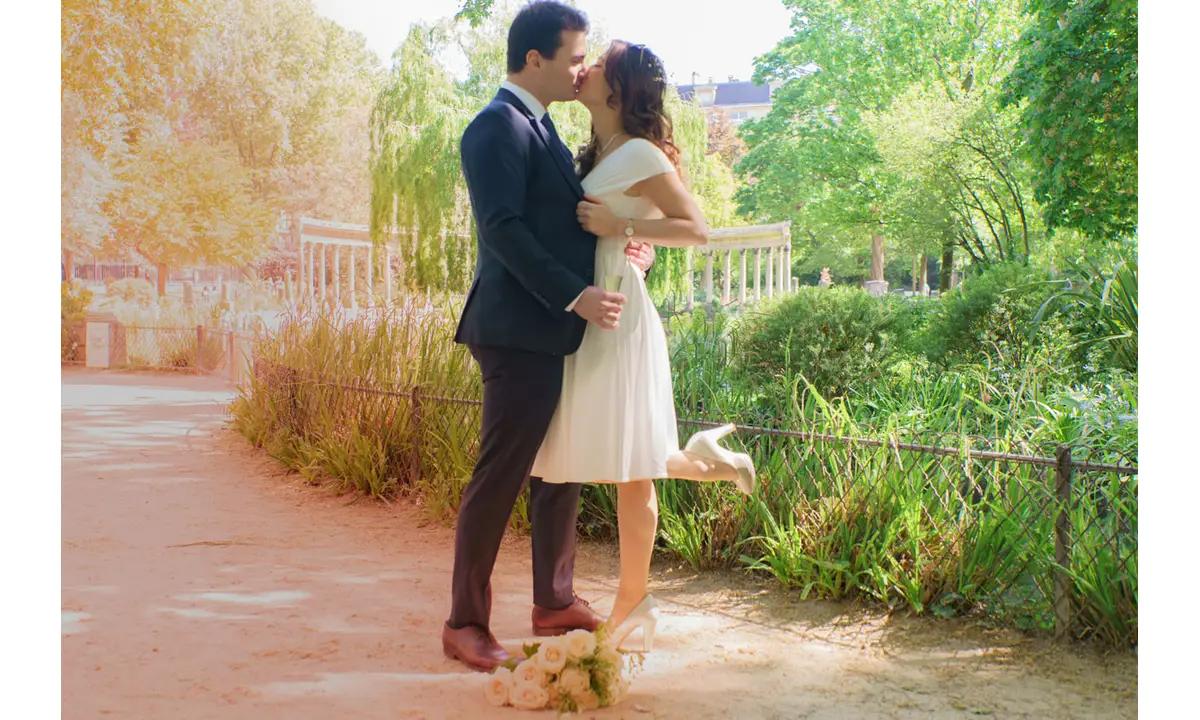 couple de mariage s'embrassant lors de la séance photo de couple apres la cérémonie de leur mariage à la maire du 8e de Paris au Parc Monceau capturée par Photographe mariage Paris.